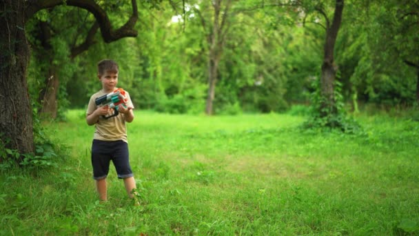 子供はおもちゃの銃を持ち、カートリッジを撃つ。2020年7月。ウクライナのキエフ. — ストック動画