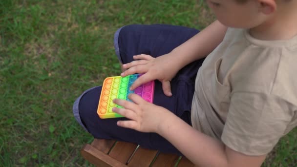 Kid Holding Rainbow Pop It Fidget Toy in handen. Jule 2020. Kiev, Oekraïne. — Stockvideo