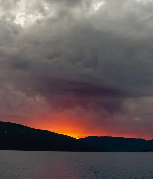 Tramonto sulle montagne, Set di dischi solari sotto l'orizzonte, il cielo è coperto di nuvole grigie simili a lenzuola. Contesto. Copia spazio — Foto Stock