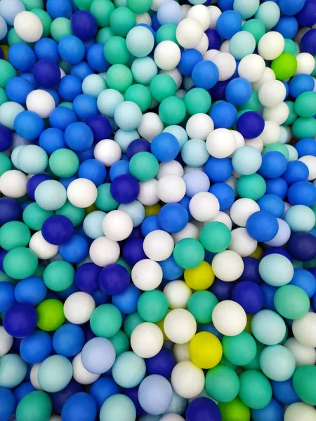 Des ballons colorés. Des ballons bleus. Couleurs de fond brillantes. Vue d'en haut sur beaucoup de boules multicolores dans la piscine sur l'aire de jeux intérieure. texture. fond. Photo verticale — Photo