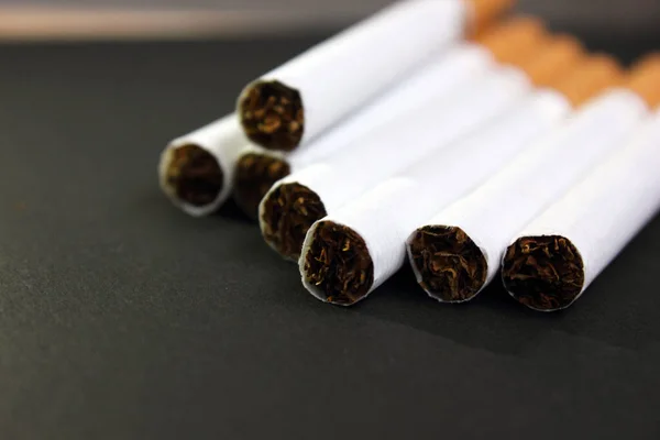 Viele Zigaretten stapelten sich auf schwarzem Grund. Das Konzept von World No Tobacco, Tobacco and Lung Health. Kopierraum. Gesundheitsschädlich. Es ist eine schlechte Gewohnheit. — Stockfoto