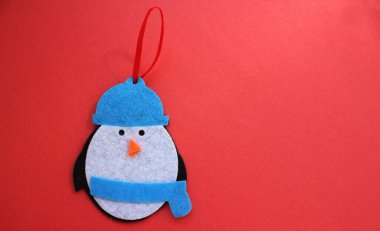 Kırmızı arka planda Noel ağacı oyuncakları. Penguen şeklinde bir oyuncak. Üst Manzara. Noel ve Yeni Yıl. Noel ağacında oyuncaklar. Çocukluk. Oyuncakları hissettim. Boşluğu kopyala
