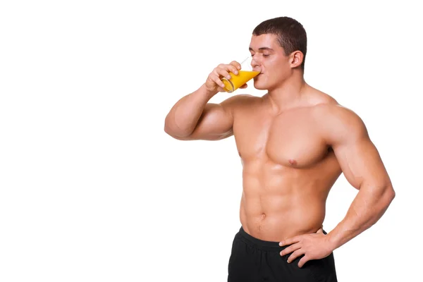 Handsome young muscular sports man drinking juice isolated on white background — Stock Photo, Image