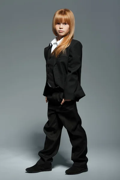 Full length little cute girl in black jacket, in black trousers, isolated over grey background — Stock Photo, Image