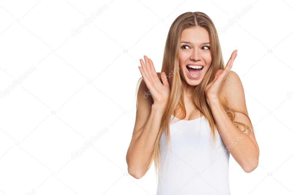 Surprised happy young woman looking sideways in excitement. Isolated over white background