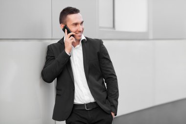 Mobil telefonda konuşurken mutlu genç bir adam