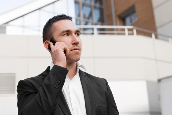 Young man talking on mobile phone looking away — Stock Photo, Image