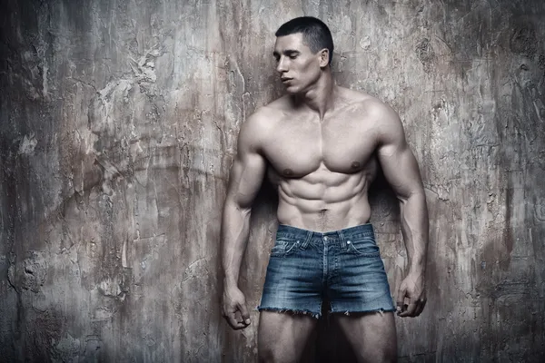 Красивый сексуальный мускулистый мужчина на фоне стены — стоковое фото