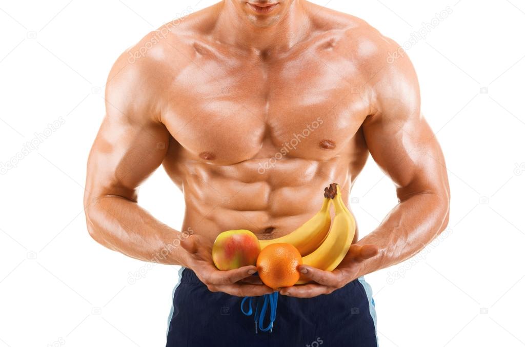 Shaped and healthy body man holding a fresh fruits, shaped abdominal, isolated on white background
