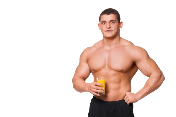 Young muscular sports man holding a glass of juice isolated on white — Stock Photo, Image