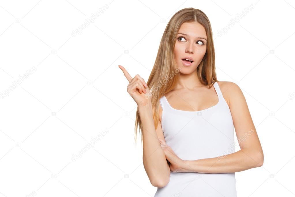 Beautiful surprised woman in excitement pointing to the side. Isolated over white background