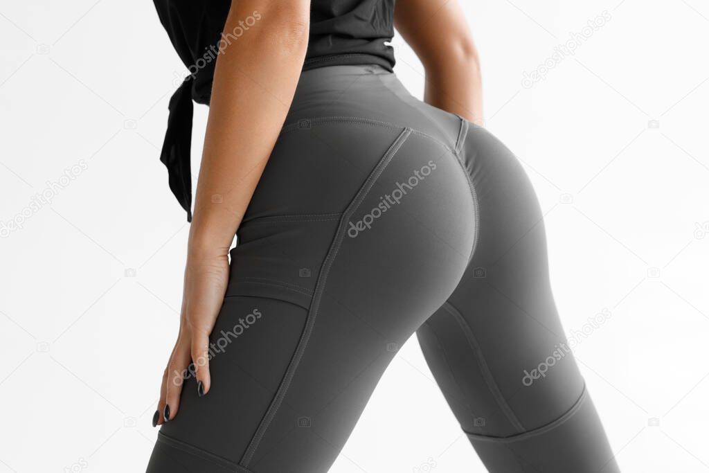 Fitness model in leggings with beautiful buttocks. Sporty booty