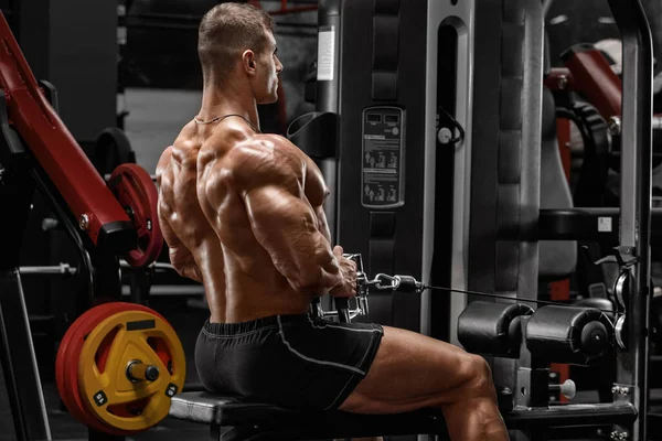 肌肉男做电缆排回来 强壮的男性在健身房锻炼 — 图库照片