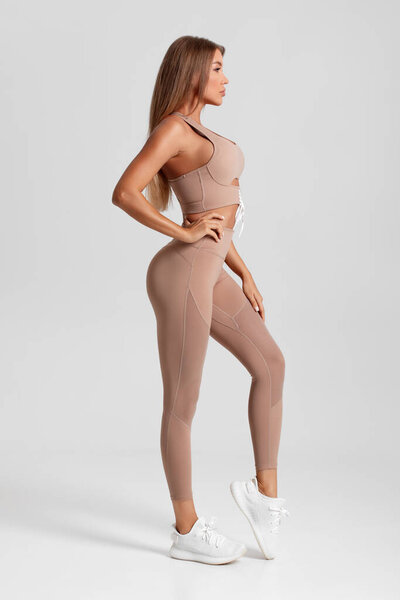 Sexy fitness woman. Beautiful athletic girl, isolated on the gray background