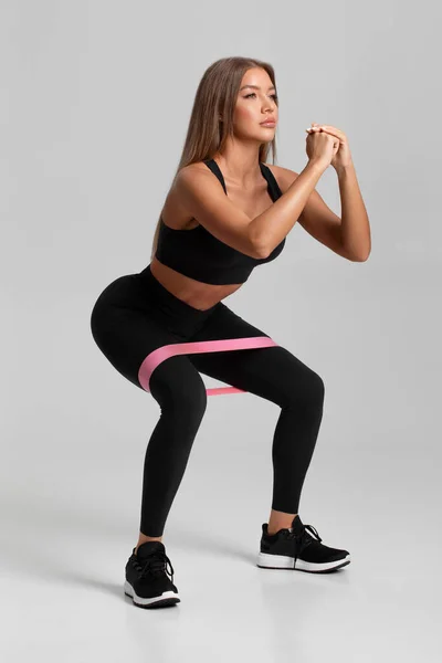 Fitness Žena Dělá Squats Cvičení Pro Glute Páskou Odporu Šedém — Stock fotografie