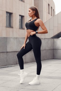 Dışarıda güzel bir fitness kadını var. Tozlu atletik kız