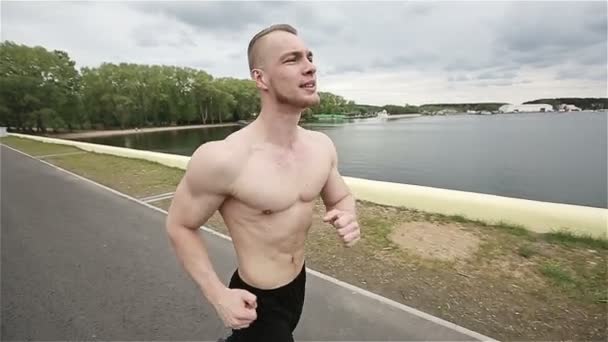 Musculoso joven corriendo al aire libre — Vídeo de stock