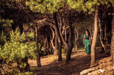 Kız ormanda yeşil giysili Adriyatik Denizi kıyısında