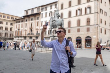 Eski bir Avrupa şehrinde haritası olan genç bir adam.