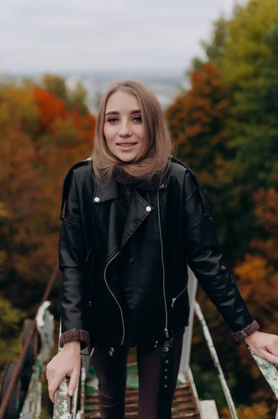 Sonbahar parkında sarışın, güzel bir kız.