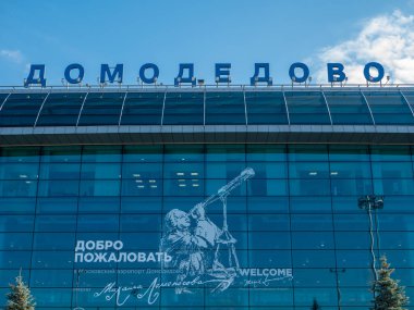 Moskova, Rusya - 5 Ekim 2021: Moskova Domodedovo Havaalanı. Mavi gökyüzüne karşı binanın çatısındaki havaalanının adı. Harfleri kapat.