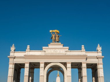 Moskova, Rusya - 5 Ekim 2021: VDNKh 'nin ana girişinin kemeri. Bir traktör sürücüsü heykeli ve kolektif bir çiftçi kemerin çatısına monte edilir. Yakın plan..