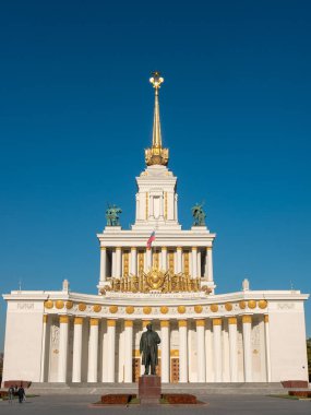 Moskova, Rusya - 5 Ekim 2021: VDNKh 'nin ana pavyonu. 97 metre yüksekliğinde kulesi olan heybetli bir bina. Çadırın yanında Lenin için bir anıt var. Dikey.