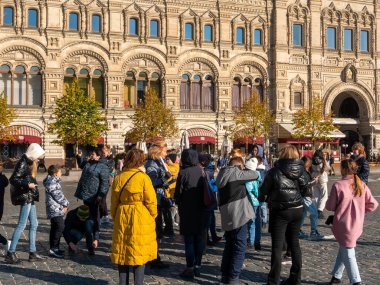 Moskova, Rusya - 5 Ekim 2021 Kızıl Meydan. GUM binasının yanında rehber standı olan bir grup turist.