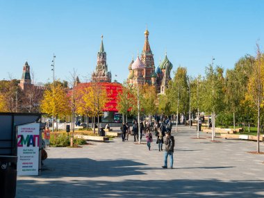 Moskova, Rusya - 5 Ekim 2021: Zaryadye Parkı Moskova Kremlin ve St. Basil Katedrali. İnsanlar güneşli bir sonbahar gününde parkta yürürler..