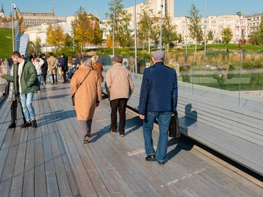 Moskova, Rusya - 5 Ekim 2021 Zaryadye parkı, yüzen köprü. İnsanlar bir sonbahar günü aileleriyle köprüden karşıya yürür..