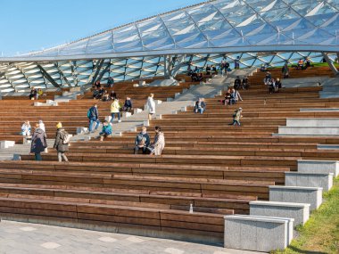 Moskova, Rusya - 5 Ekim 2021 Zaryadye Parkı. İnsanlar güneşli bir sonbahar gününde Zaryadye konser salonunun amfi tiyatrosunda yürürler ve dinlenirler..