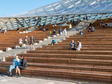Moskova, Rusya - 5 Ekim 2021 Zaryadye Parkı. İnsanlar güneşli bir sonbahar gününde Zaryadye konser salonunun modern büyük amfi tiyatrosunu ziyaret ederler..