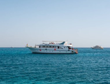 Hurghada, Mısır - 22 Eylül 2021: İnsanlar gök mavisi kızıl denizde büyük bir yatta dinlenip dinleniyorlar. Turistlere şnorkelle yüzme ve dalış teklif ediliyor..