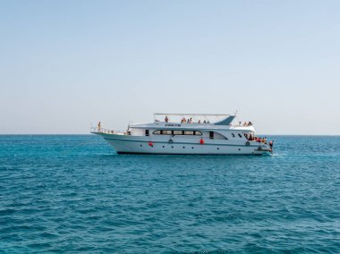 Hurghada, Mısır - 22 Eylül 2021: İnsanlar gök mavisi kızıl denizde büyük bir yatta dinlenip dinleniyorlar. Turistlere güzel adaların yakınında dalış ve şnorkelle yüzme sunuluyor..