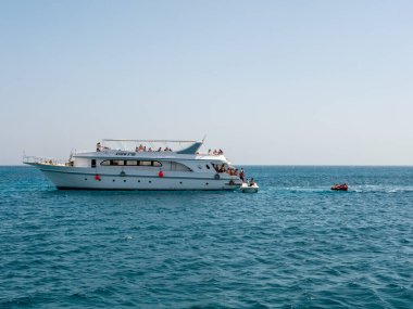 Hurghada, Mısır - 22 Eylül 2021: İnsanlar gök mavisi kızıl denizi geçmek için sırada bekliyorlar.