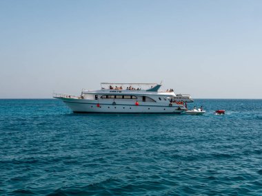 Hurghada, Mısır - 22 Eylül 2021: İnsanlar büyük bir yatta dinleniyor ve gök mavisi kızıl denizde su çekimleri yapıyorlar..