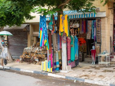 Kahire, Mısır - 30 Eylül 2021: yerel turist dükkanları olan Kahire Caddesi. Parlak doğulu giysiler ve hediyelik eşyalar mağazanın dışında satılıyor..