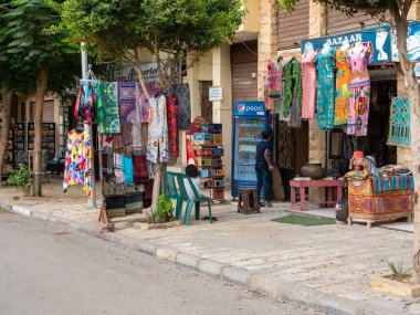 Kahire, Mısır - 30 Eylül 2021: Kahire caddesi yerel turist dükkanları ve kafeleri ile. Doğu tarzı parlak elbiseler mağazada satılıktır..