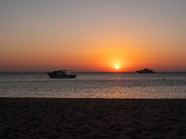Hurghada, Mısır - 3 Ekim 2021: Mısır 'da Kızıldeniz' de güzel bir gün doğumu. Yatlar ufukta yükselen güneşin arka planına karşı denizde duruyor. Gökyüzündeki parlak renkler.