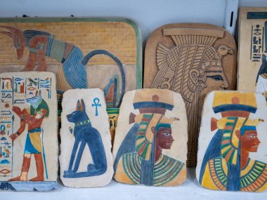 Eski tanrıların ve hayvanların Mısır temalı çizimlerinin yer aldığı bir hediyelik eşya dükkanında renkli taş tabletler. Luxor, Mısır.