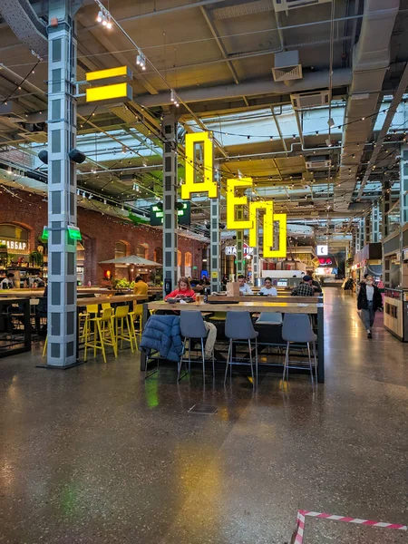 Moskova, Rusya - 22 Eylül 2021: Moskova Depot Gıda Merkezi binası. İnsanlar masalarda oturup yemek yiyorlar. Kompleksin bölgesinde birçok restoran ve kafe vardır. Dikey.