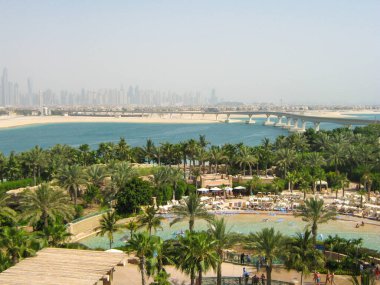 Dubai, BAE - 3 Haziran 2013 Aquaventure Waterpark 'ın güzel manzarası. İnsanlar rahatlar ve yeşil palmiye ağaçları arasında havuz kenarında güneşlenirler..