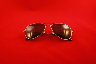 ışık yansıması ve kırmızı arka plan ile katlanmış güneş gözlüğü