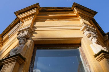 Heykelleri olan eski bir binanın penceresi. Terk edilmiş malikane Mikhailovka Sarayı