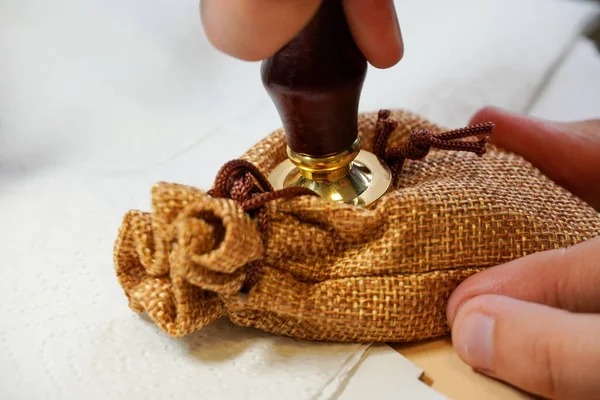 La fabricación del sello de cera en el arte de una bolsa de lino. Dedos de hombre. Hecho a mano. —  Fotos de Stock