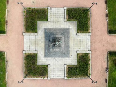 Lenin anıtı güvercinlerle dolu bir kaidede. Elleri açık şapkalı bir adam. 