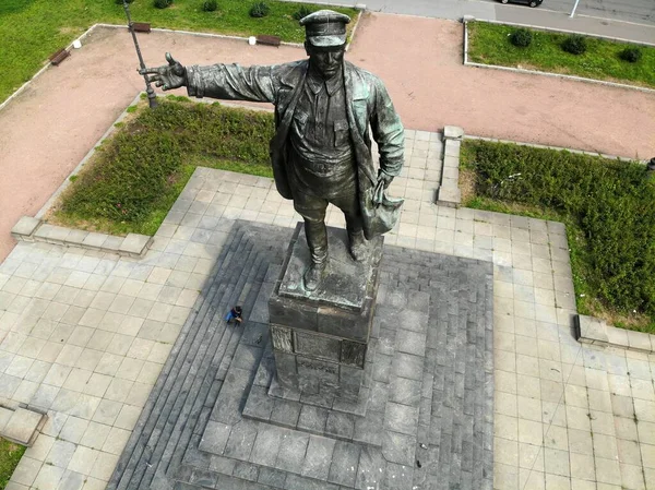 Lenin monument on a pedestal with pigeons. Man in a cap with outstretched hand — Stockfoto