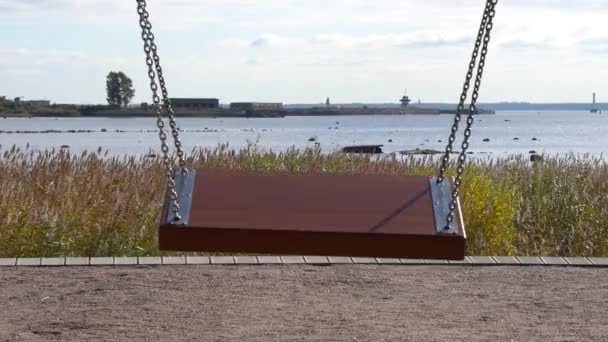Huśtawka w pobliżu jeziora wody morskiej ławce. Park Forty Wyspa Kronshtadt Sankt-Petersburg — Wideo stockowe