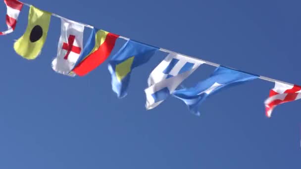 Petits drapeaux marins nautiques sur le navire contre un ciel bleu avec un nuage — Video