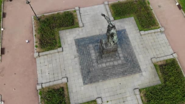 Lenin monument op een sokkel met duiven. Man met een kap met uitgestrekte hand — Stockvideo